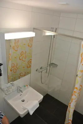 a bathroom with a sink and a shower at Hotel Garni Bären Bazenheid in Bazenheid