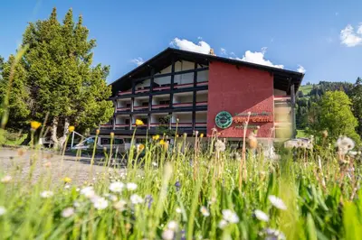 a building with a field of flowers in front of it at Hotel Säntis Lodge in Unterwasser