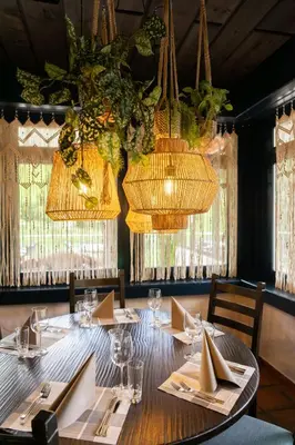 a table in a restaurant with chandeliers at Hotel Säntis Lodge in Unterwasser