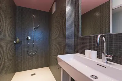 a bathroom with a sink and a shower at Hotel Dom, zentral - herzlich - sozial engagiert in St. Gallen