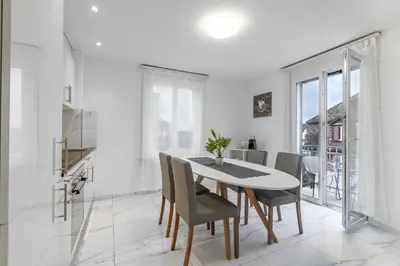 a kitchen and dining room with a table and chairs at Aparthotel Mama Home Arbon in Arbon