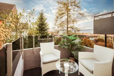 a balcony with two chairs and a glass table at VISIMO Apartments Lehnstrasse St Gallen - Stylish, Smart, Connected in St. Gallen