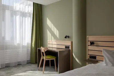 a bedroom with a desk and a chair next to a bed at flexymotel Buchs in Buchs