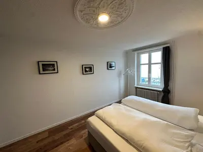 a living room with a couch and a window at Lakeside Apartments Rorschach - easy self check-in in Rorschach