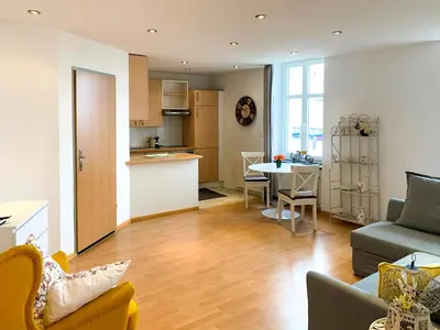 a living room and kitchen with a couch and a table at Lakeside Apartments Rorschach - easy self check-in in Rorschach