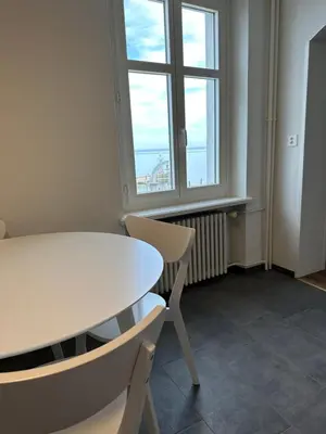 a white table and chairs in a room with a window at Lakeside Apartments Rorschach - easy self check-in in Rorschach