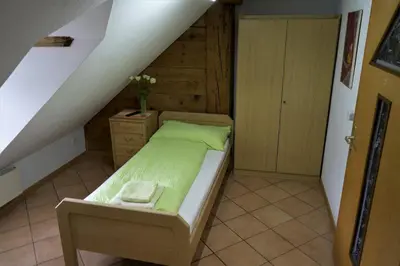 a small bedroom with a bed and a staircase at Hotel Linde Goldach in Goldach