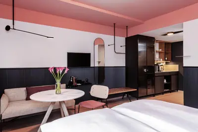 a living room with a couch and a table at Sorell Boutique-Hotel City Weissenstein St Gallen in St. Gallen
