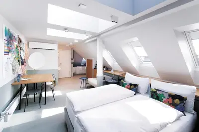 a bedroom with a bed and a dining room at Sorell Boutique-Hotel City Weissenstein St Gallen in St. Gallen