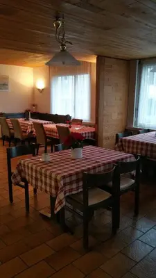 a restaurant with tables and chairs in a room at Hotel Ochsen in Sankt Margrethen