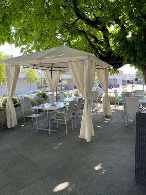 a table and chairs under a large umbrella at Hotel Ochsen in Sankt Margrethen