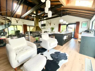 a living room with two white chairs and a kitchen at Ski-InOut 4BR Alpen Chalet, Views & Fire in Alt Sankt Johann