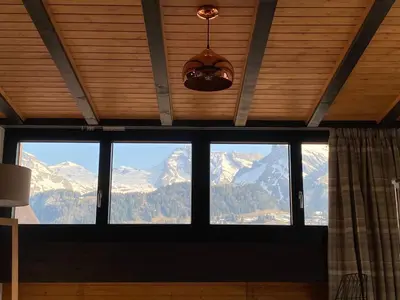 a room with a large window with a view of mountains at Ski-InOut 4BR Alpen Chalet, Views & Fire in Alt Sankt Johann