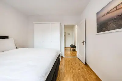 a bedroom with a large white bed and a hallway at SOHO 1A !Gratis Parken, Free Parking! in Kreuzlingen