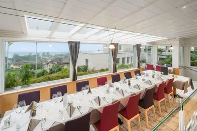 a conference room with tables and chairs and large windows at Best Western Hotel Rebstock in Rorschacherberg
