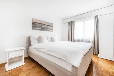 a white bedroom with a large bed and a window at SOHO 9 !Gratis Parken, Free Parking! in Kreuzlingen