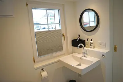 a bathroom with a sink and a mirror and a window at Alte Metzg - Boutique Pension in Appenzell