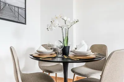 a black dining room table with chairs and a vase of flowers at SOHO 5A !Gratis Parken, Free Parking! in Kreuzlingen