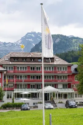 a hotel with a flag in front of a building at Hotel Sternen Unterwasser in Unterwasser