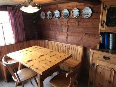a wooden table in a room with clocks on the wall at Alphütte Burst in Alt Sankt Johann