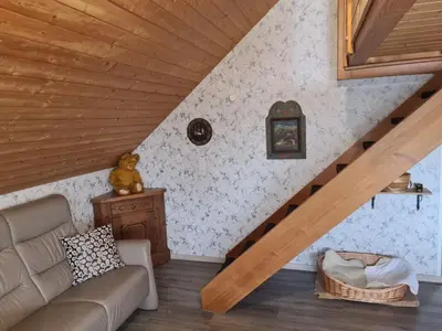 a living room with a couch and a staircase at Alpen-Paradies Edelweiss in Urnäsch