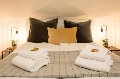 a bed with white towels and pillows on it at INN JOY Apartments - Sankt Gallen West in St. Gallen