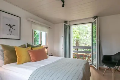 a bedroom with a large bed and a balcony at INN JOY Apartments - Sankt Gallen West in St. Gallen