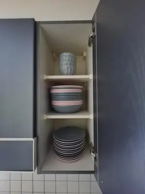 a cupboard with plates and bowls in a kitchen at HOME AWAY FROM HOME in Staad