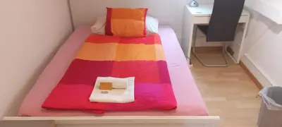 a bed with a colorful blanket on it in a room at Gemütliche Dachwohnung in St. Gallen
