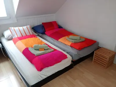 two beds with colorful blankets on them in a room at Gemütliche Dachwohnung in St. Gallen