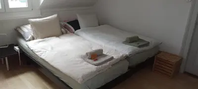 a small bedroom with two twin beds with towels at Gemütliche Dachwohnung in St. Gallen