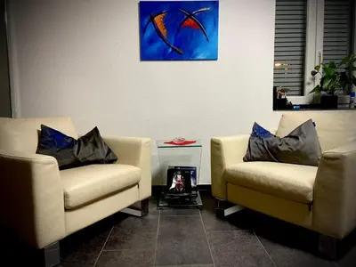a living room with two couches and a painting on the wall at Spielzimmer am Bodensee in Rorschach