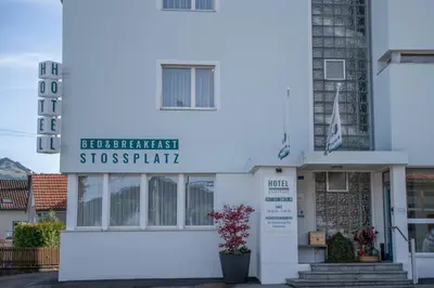a white building with a sign on it at Hotel B&B Stossplatz anytime and easy self Check-in in Appenzell