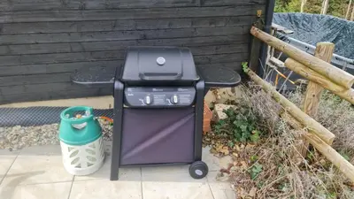a barbecue grill sitting next to a trash can at Grosses Ferienhaus für traumhafte Familienferien im Appenzellerland in Speicher