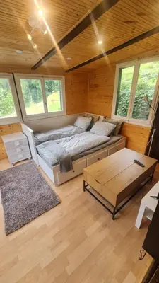 a bedroom with a bed and a table in a room at Grosses Ferienhaus für traumhafte Familienferien im Appenzellerland in Speicher