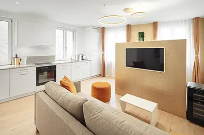 a living room with a couch and a kitchen at VISIMO Apartments Mühlensteg St Gallen - Elegant Quiet Central in St. Gallen