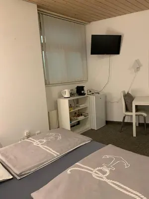 a bedroom with a bed with a television and a table at Guest room David 11 in St. Gallen