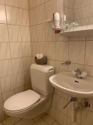 a white bathroom with a toilet and a sink at Guest room David 11 in St. Gallen