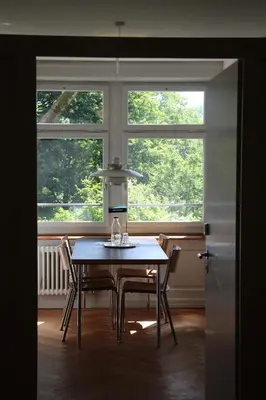 a dining room with a table and two windows at Militärkantine St. Gallen in St. Gallen