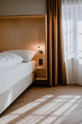 a bed with a mirror next to a window at Hotel Müllers - Self-Check-in in Arbon