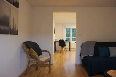 a bedroom with a bed and a chair and a desk at Casa Schilling 2,5 rooms in St Gallen, modern, quiet and close to the center in St. Gallen