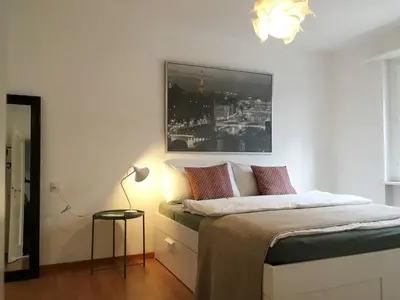 a bedroom with a bed with a picture on the wall at 2 rooms with balcony, central, quiet location in St. Gallen