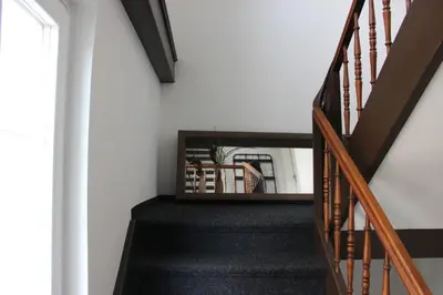 a staircase in a house with a mirror on the wall at Completely renovated apartment near the train station and the center in St. Gallen