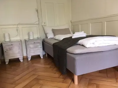 a bedroom with two beds and two night stands at Casa Schilling - 4 charming rooms in the best location in St. Gallen