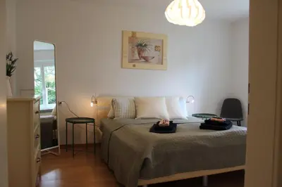 a bedroom with a bed and two tables and a mirror at Nice apartment with sun terrace in St. Gallen