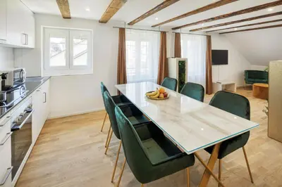 a kitchen and dining room with a table and chairs at VISIMO Apartments Steigerstrasse St Gallen - Modern Living near OLMA & Hospital in St. Gallen