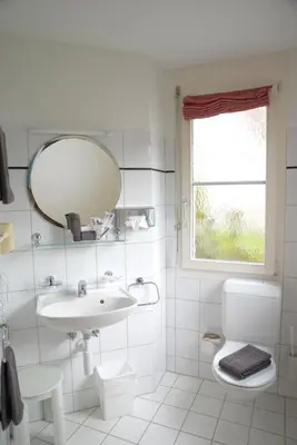 a white bathroom with a sink and a mirror at Hotel Garni Arnegg in Arnegg