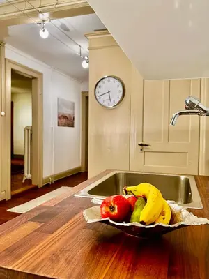 a bowl of fruit on a kitchen counter with a clock at Villa Bergruh in St. Gallen