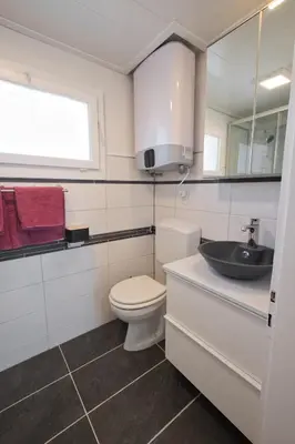 a white bathroom with a toilet and a sink at Lake Getaway Apartment with Private entrance, right on the Lake Constance cycle path, barbecue area, free wifi, Netflix and free bikes in Salmsach