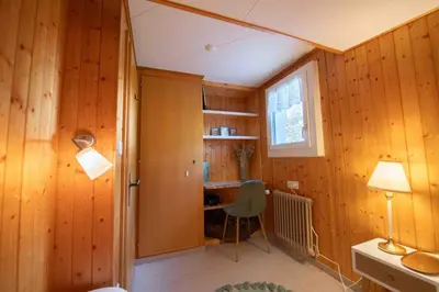 a room with wooden walls and a desk and a window at Capanna in Wildhaus